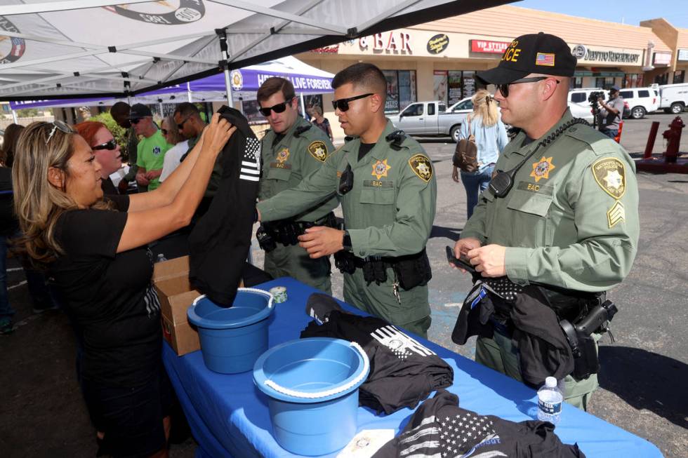 Benjawan Munson, left, sells T-shirts to, from left, A. Loos, L. Vidal and Robert Rafferty duri ...