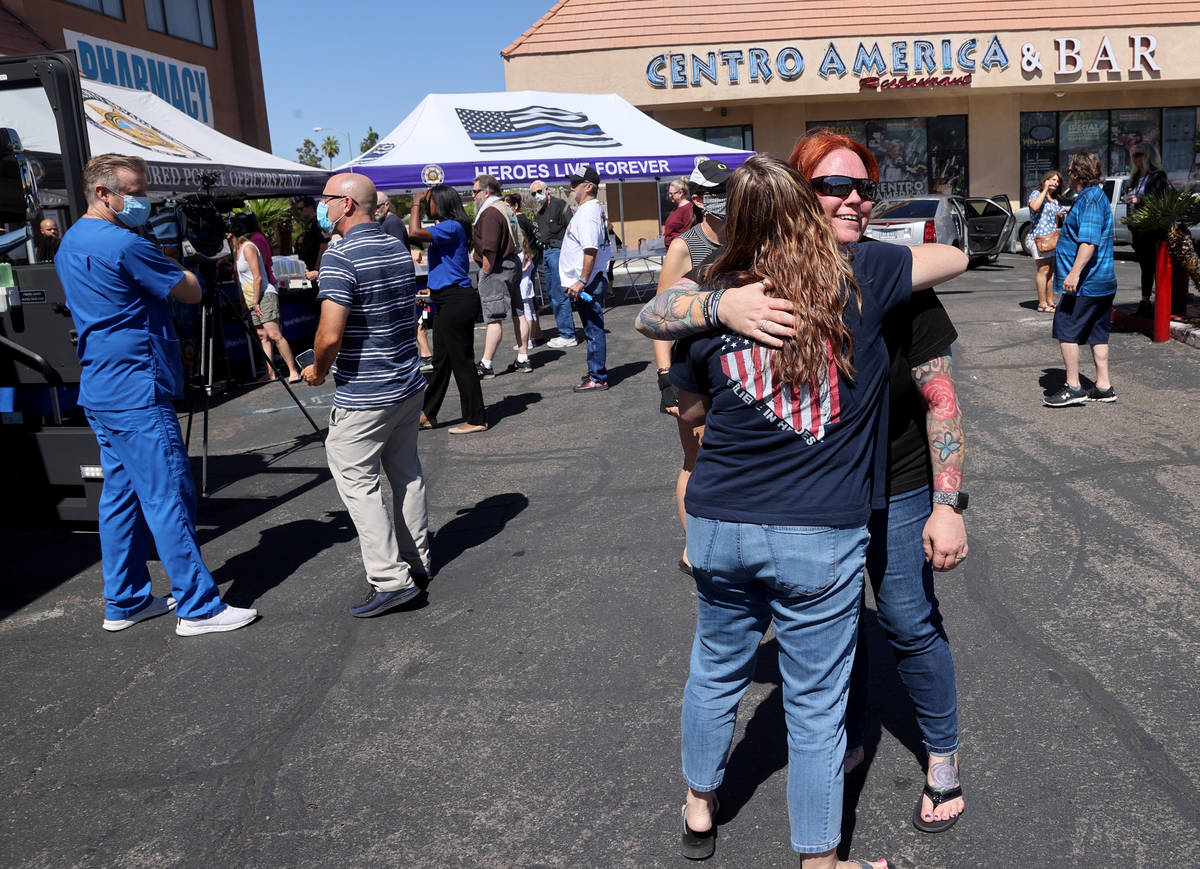Las Vegas police officer Christina Pettit, right, hugs "Metro wife" Julie Hutchinson ...