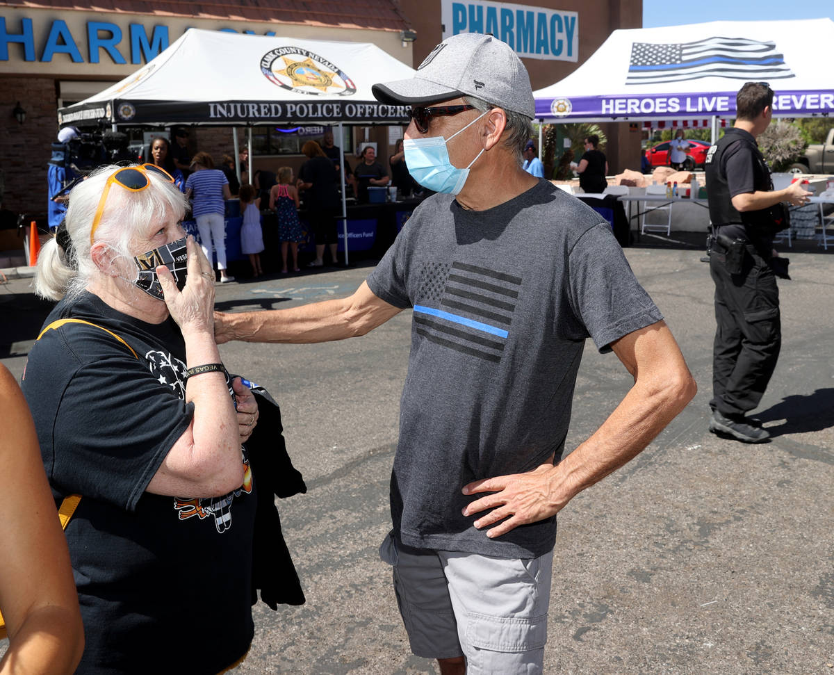 Guy Mikalonis, right, father of Las Vegas police officer Shay Mikalonis gets support from Patti ...