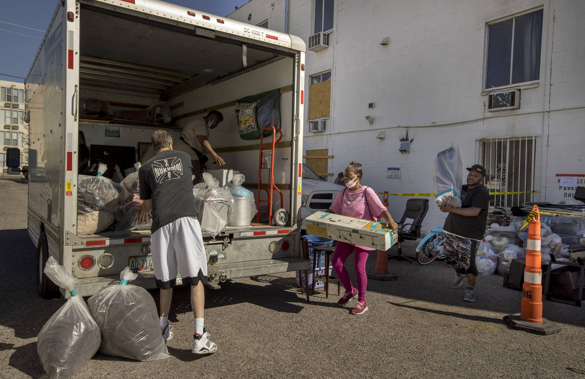 Former resident Helen Clark, center, carries over her and Audrey Palmer's possessions to a movi ...