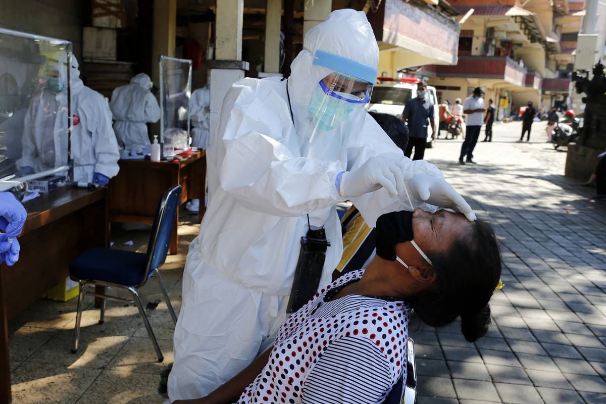 A heath worker takes a nasal swab sample during a public testing for the new coronavirus conduc ...