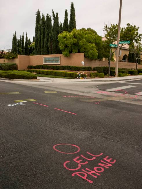 Police spray paint outlines a cell phone spot on the road mark where two teen brothers were kil ...