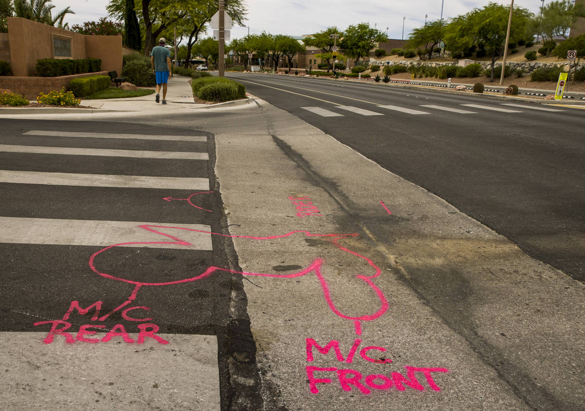 Police spray paint outlines on the road mark where two teen brothers were killed in a recent mo ...