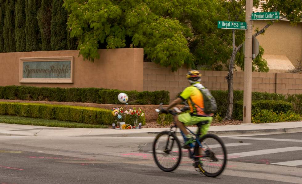 A cyclist looks to a small memorial near where two teen brothers were killed in a recent motorc ...