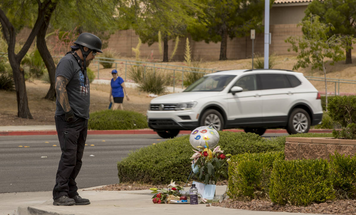 Motorcyclist Doug Durbin stops by a small memorial near where two teen brothers were killed in ...