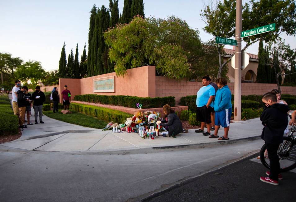 Marianne Littledike, center, lights candles as people gather for a vigil in memory of David Cox ...