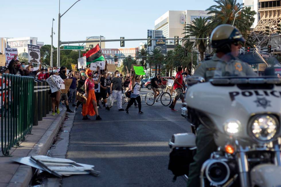 Protesters, who are calling for the police to be defunded and denouncing police brutality, move ...