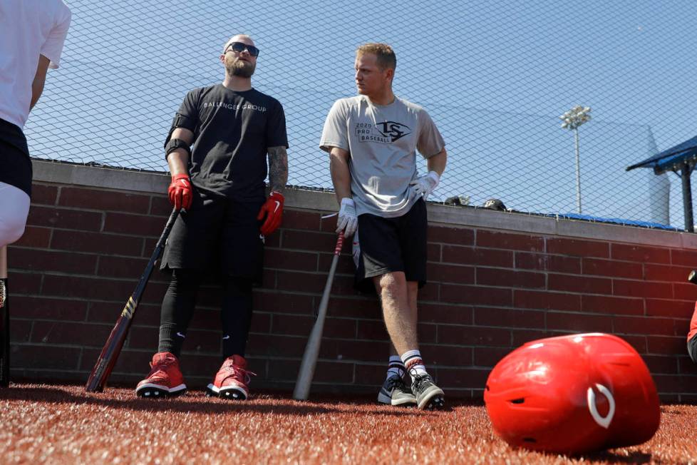 Cincinnati Reds' Tucker Barnhart, left, talks with Josh VanMeter during a workout at Grand Park ...