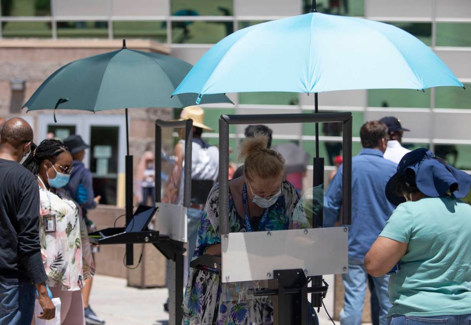 A shield to prevent coronavirus spread is between employees and customers at the Nevada Departm ...