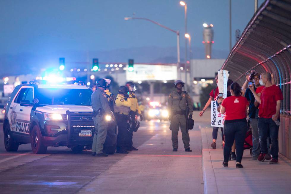 Legal observers watch as someone is arrested during a protest against police brutality on Satur ...