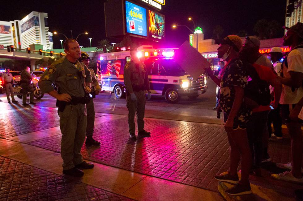 A protester argues with a Las Vegas Metropolitan Police officer as an ambulance arrives to take ...