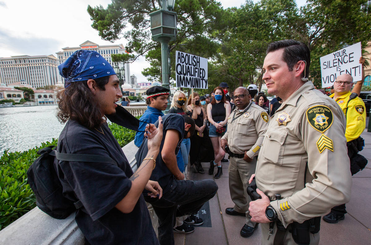 Black Lives Matter protesters speak with Las Vegas police officers in front of the Bellagio fou ...