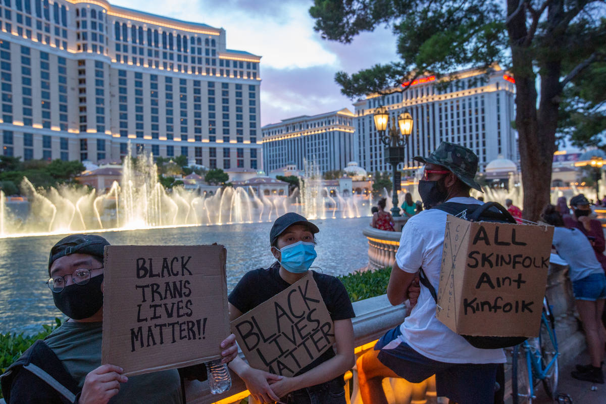 Black Lives Matter protesters hold signs in front of the Bellagio fountains in Las Vegas on Mon ...