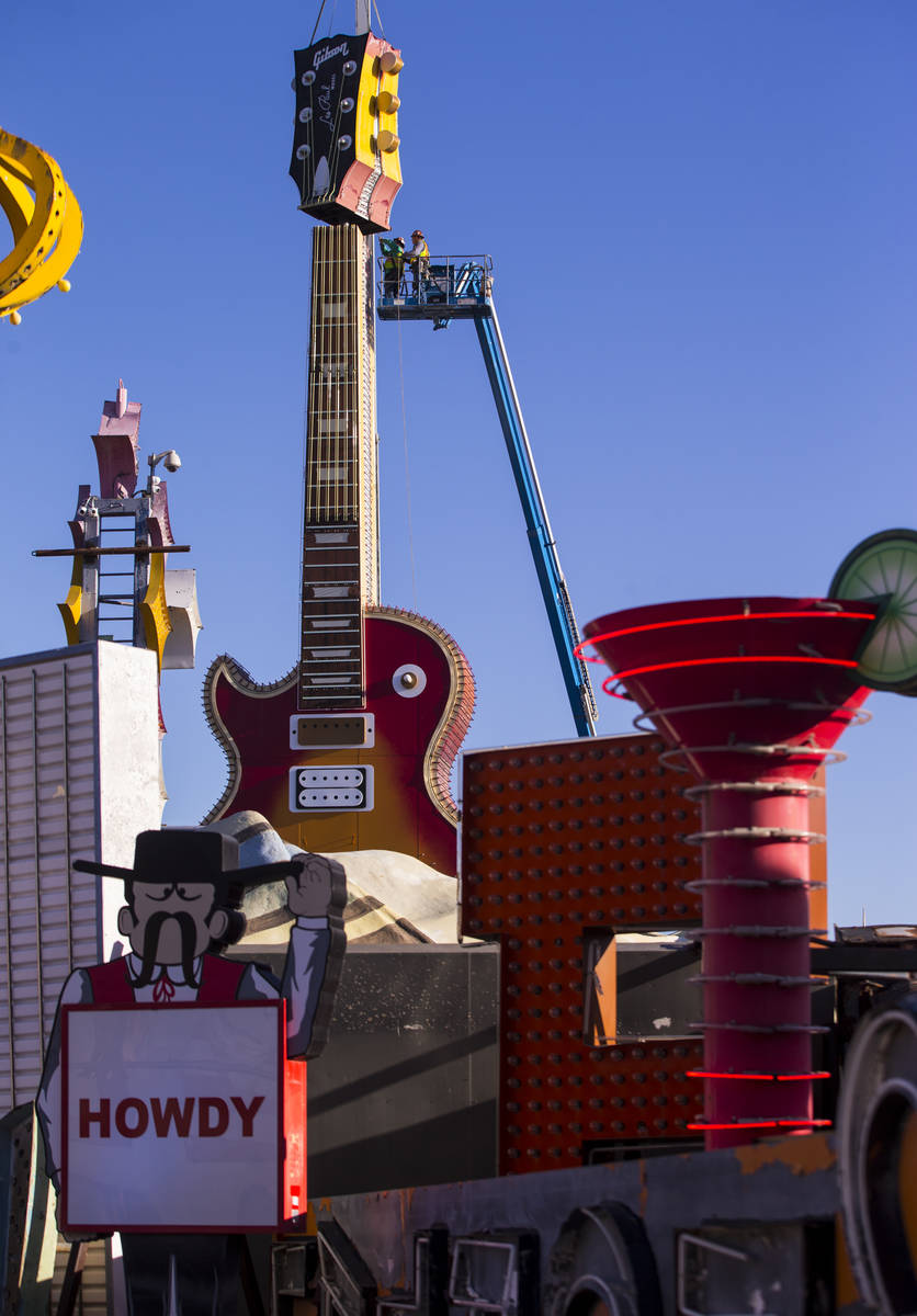 The headstock piece of the Hard Rock Cafe guitar sign is raised into the air as YESCO employees ...