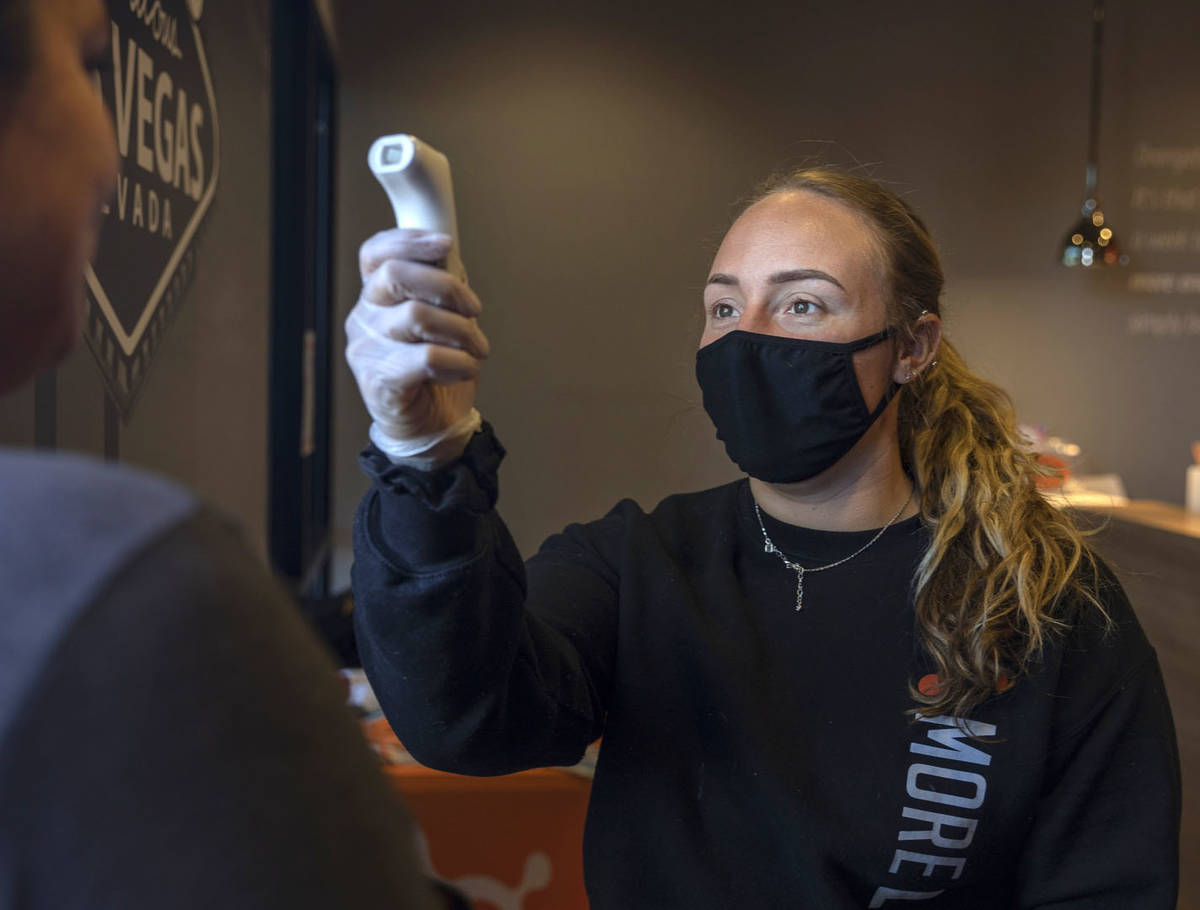 Orangetheory Fitness sale associate Megan Rabe checks the temperature of members at the locatio ...