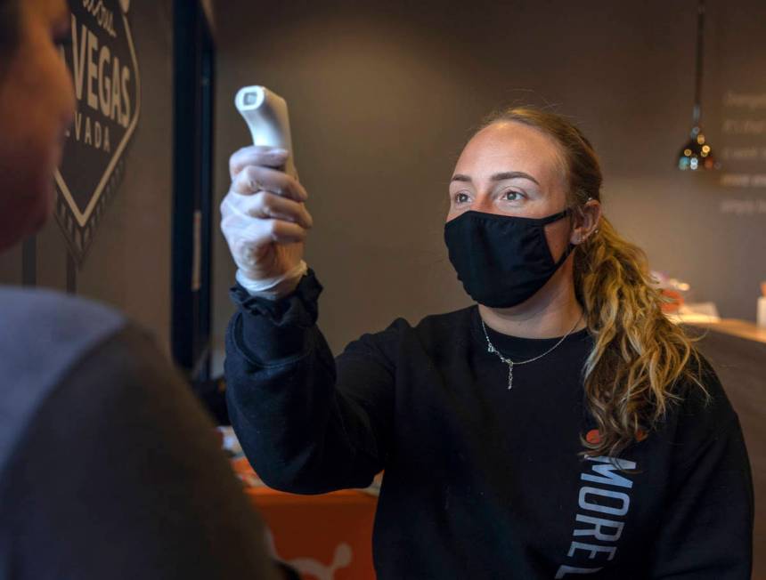 Orangetheory Fitness sale associate Megan Rabe checks the temperature of members at the locatio ...