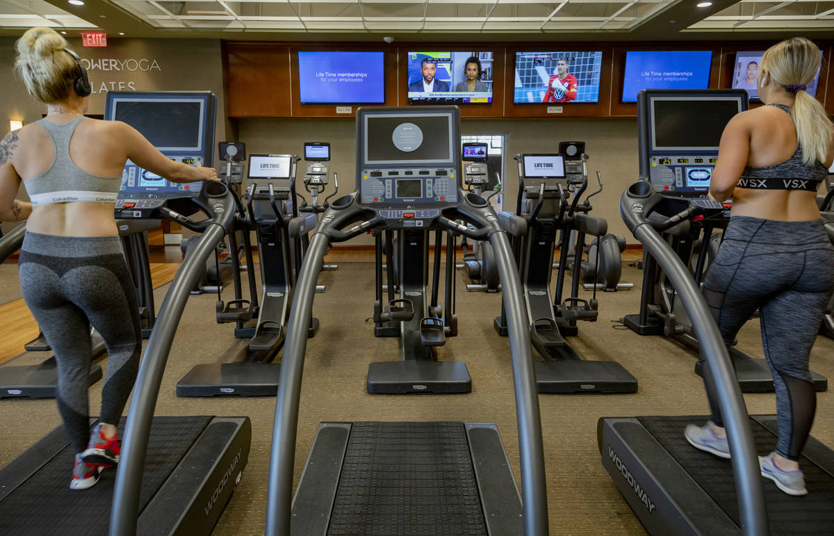 Life Time Fitness members practice social distancing while on treadmills at the Life Time Fitne ...