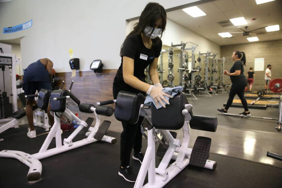 Lisa Torres cleans workout equipment at the EOS Fitness gym in Henderson, Tuesday, June 16, 202 ...