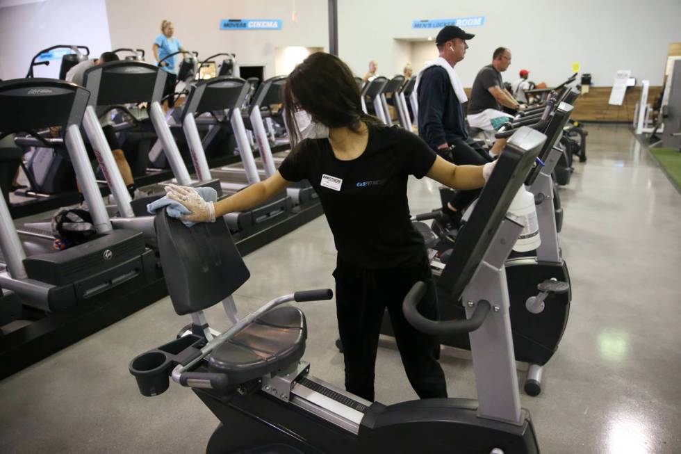 Lisa Torres cleans workout equipment at the EOS Fitness gym in Henderson, Tuesday, June 16, 202 ...