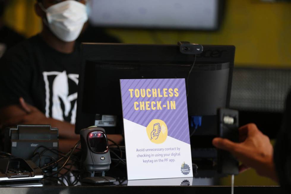 A person uses a phone to check-in at the Planet Fitness gym in Las Vegas, Tuesday, June 16, 202 ...