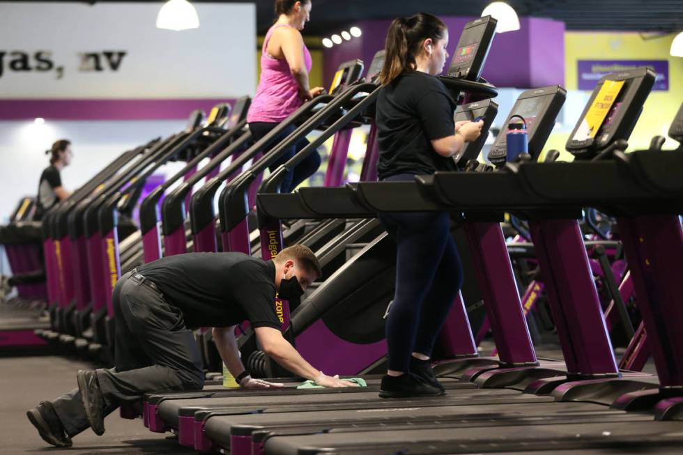 Manager Hunter Jespersen wipes downs a treadmill at the Planet Fitness gym in Las Vegas, Tuesda ...