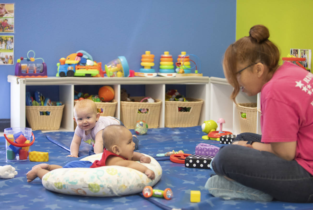 Lorenzo smiles at Miss Brenda while Zoe plays in the background at Rising Star Preschool & ...