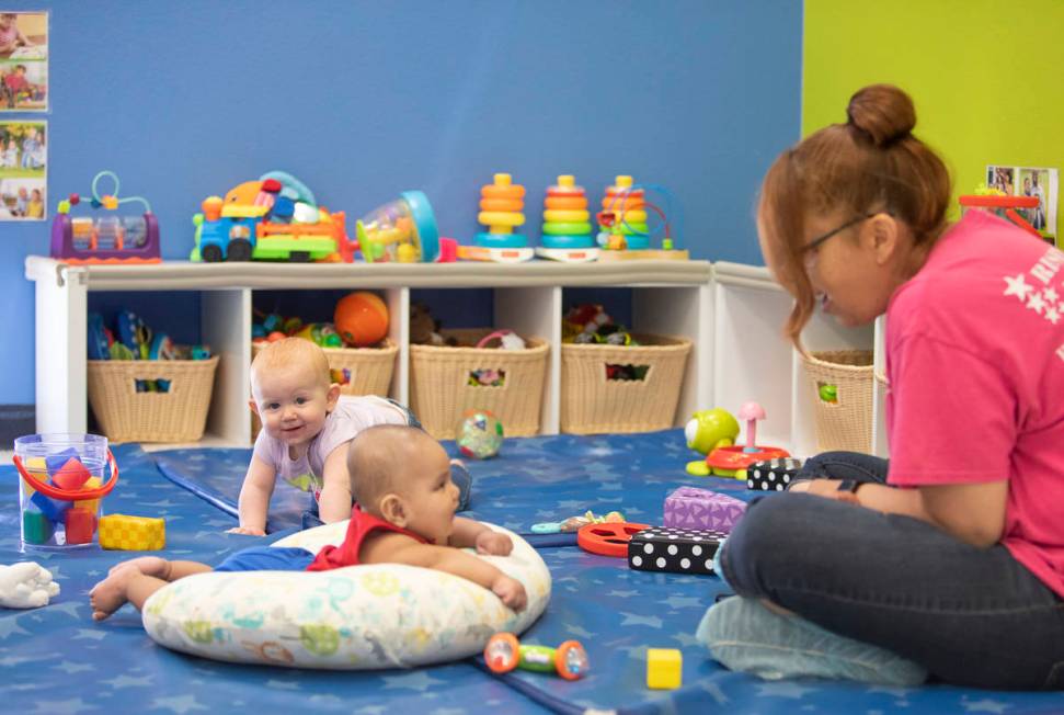 Lorenzo smiles at Miss Brenda while Zoe plays in the background at Rising Star Preschool & ...