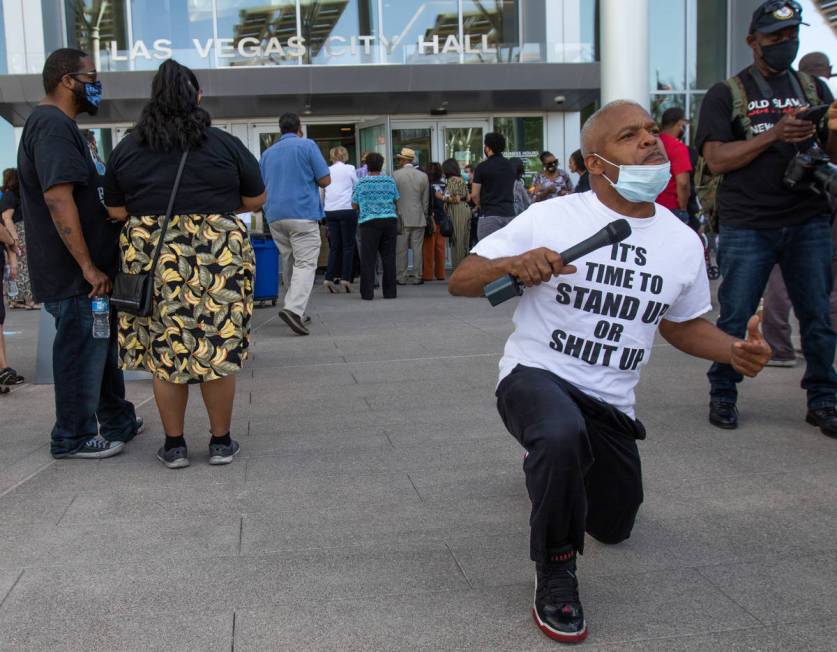 Henry Thorns takes a knee while shouting "get your knee off my neck" at an NAACP protest in fro ...