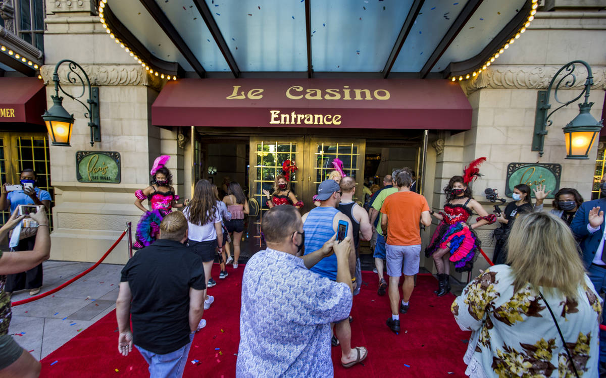 Guests stream into the Paris Las Vegas past French-inspired can-can dancers after the reopening ...