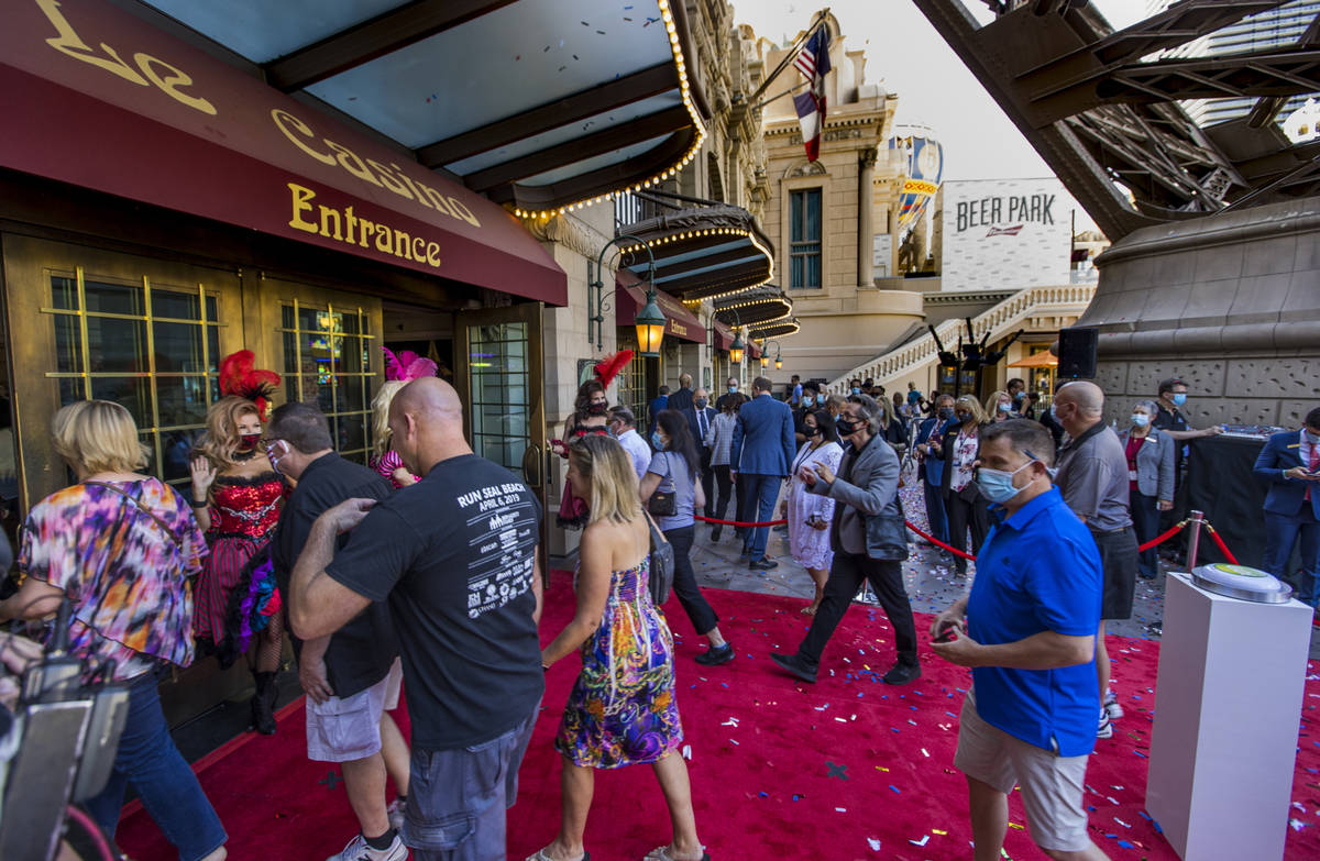 Guests stream into the Paris Las Vegas past French-inspired can-can dancers after the reopening ...