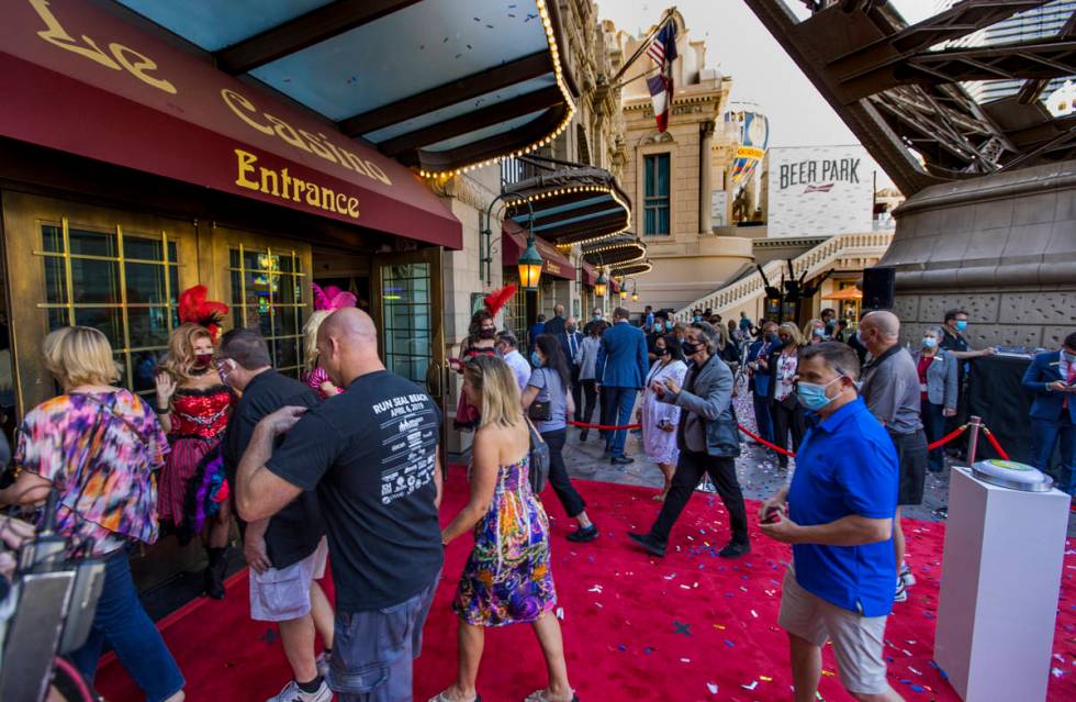 Guests stream into the Paris Las Vegas past French-inspired can-can dancers after the reopening ...