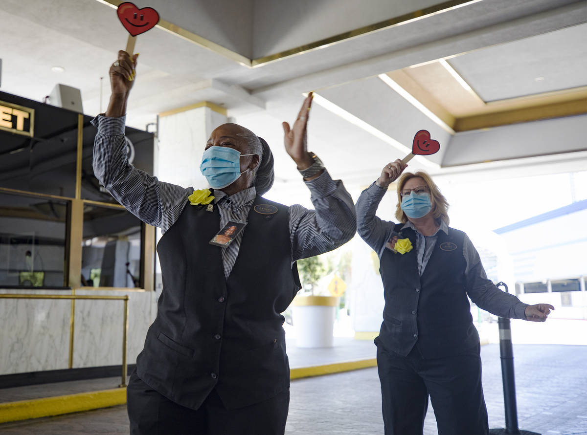 Lyndia Brown, left, a front desk agent, waves signs with fellow front desk agent Alita Fever as ...