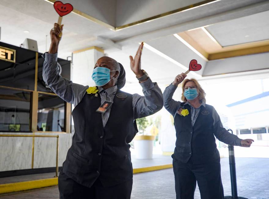 Lyndia Brown, left, a front desk agent, waves signs with fellow front desk agent Alita Fever as ...