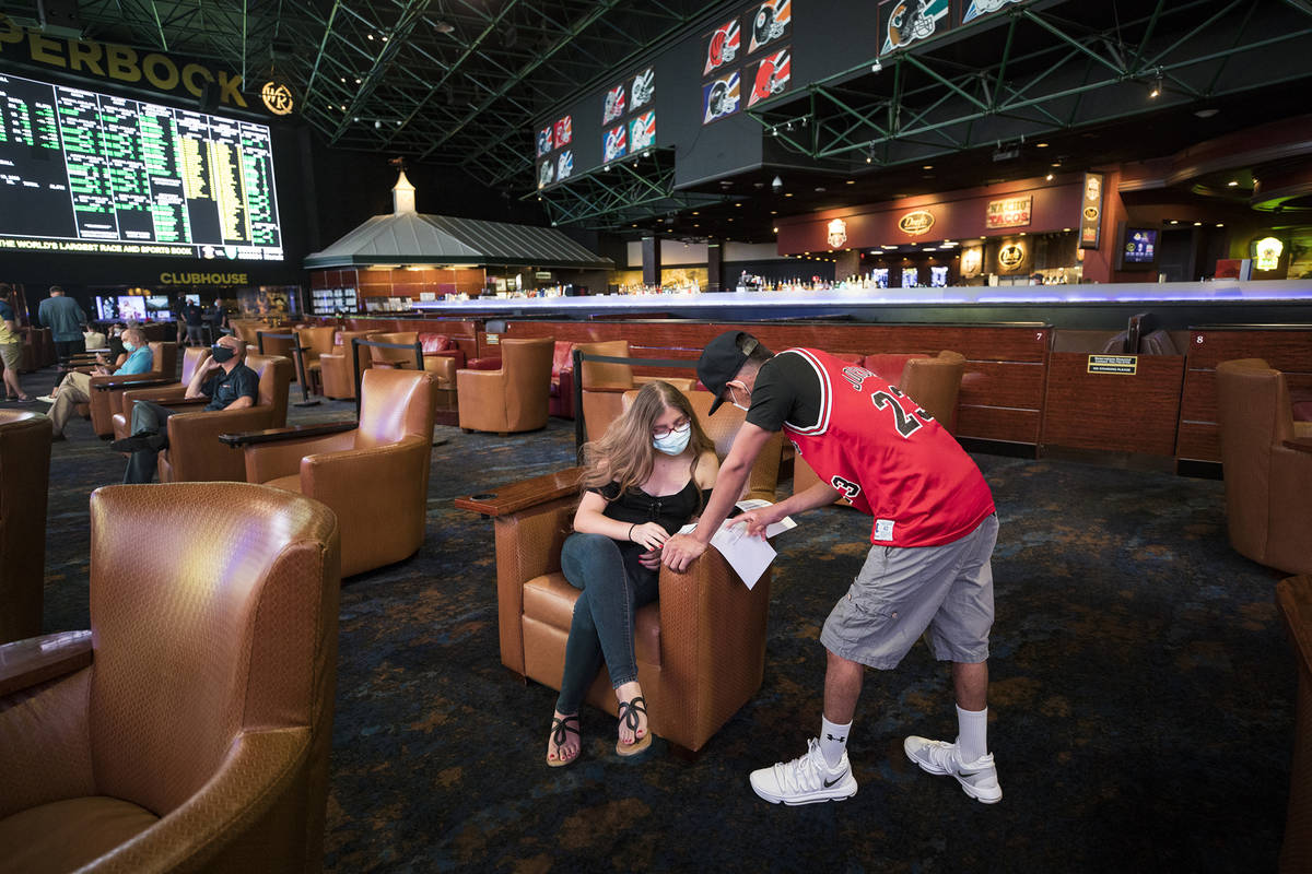 Irene Rodriguez, left, decides on what to bet with her boyfriend Reuben Gutierrez, right, at th ...