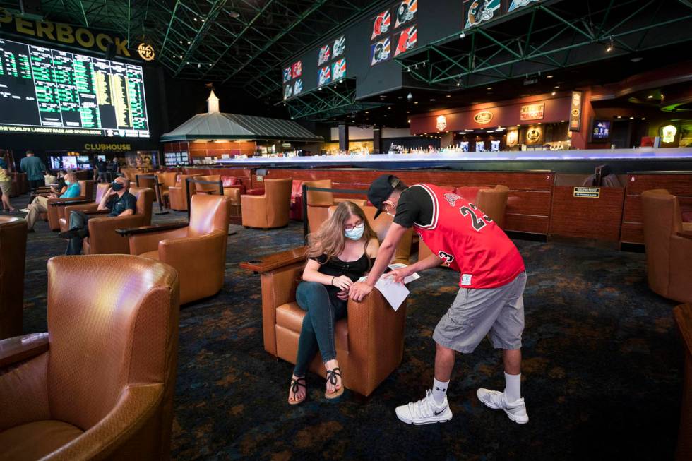 Irene Rodriguez, left, decides on what to bet with her boyfriend Reuben Gutierrez, right, at th ...