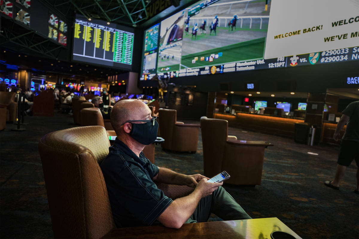 Tom Mitchell, of Las Vegas, watches screens in the Westgate Sportsbook on the first day of the ...
