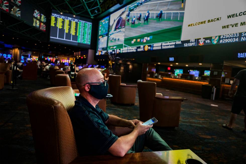 Tom Mitchell, of Las Vegas, watches screens in the Westgate Sportsbook on the first day of the ...