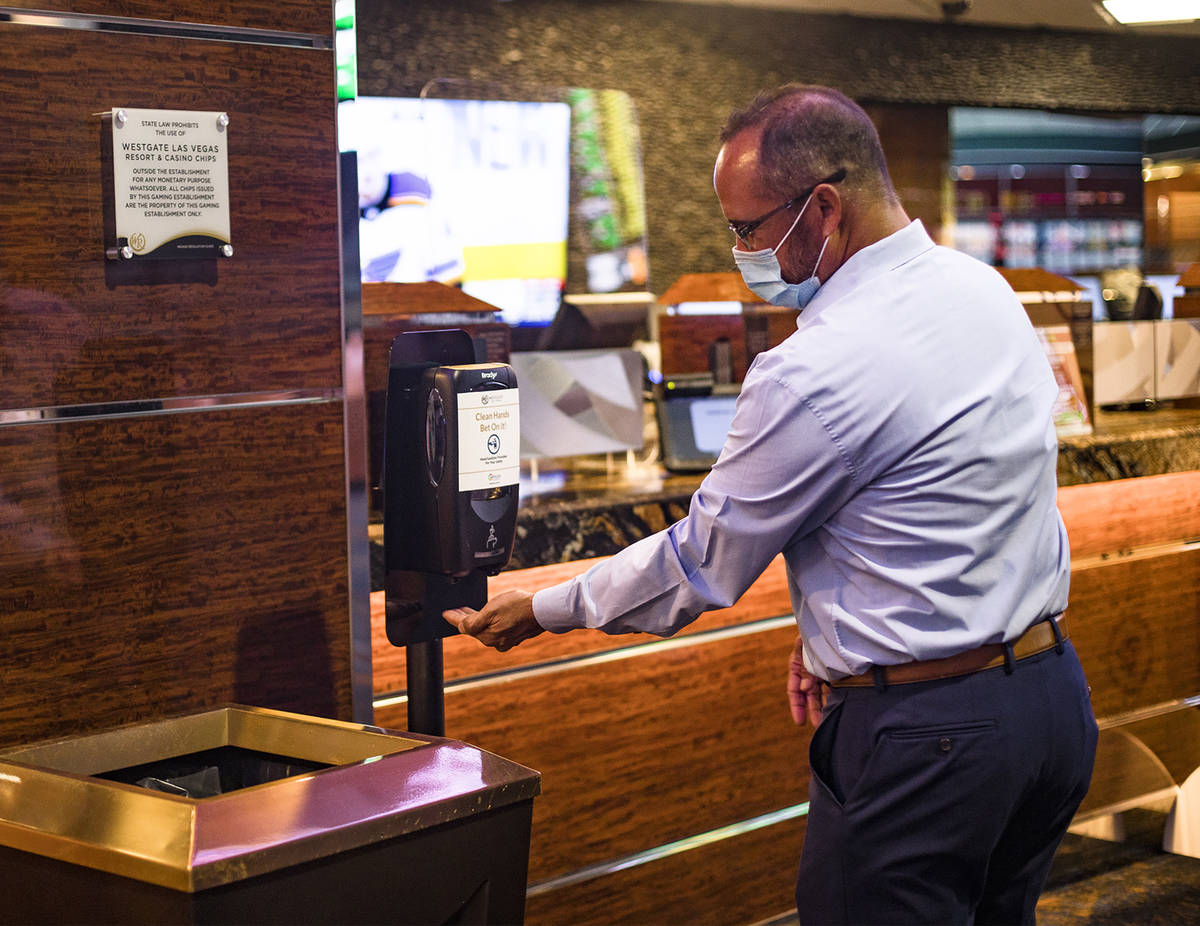 Jay Kornegay, vice president of Westgate Sportsbook, uses a hand sanitizer station on the first ...