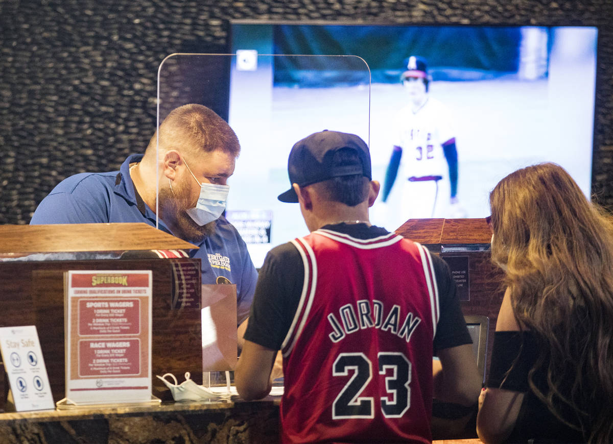 Customers place bets at the Westgate Sportsbook on the first day of the casino reopening after ...