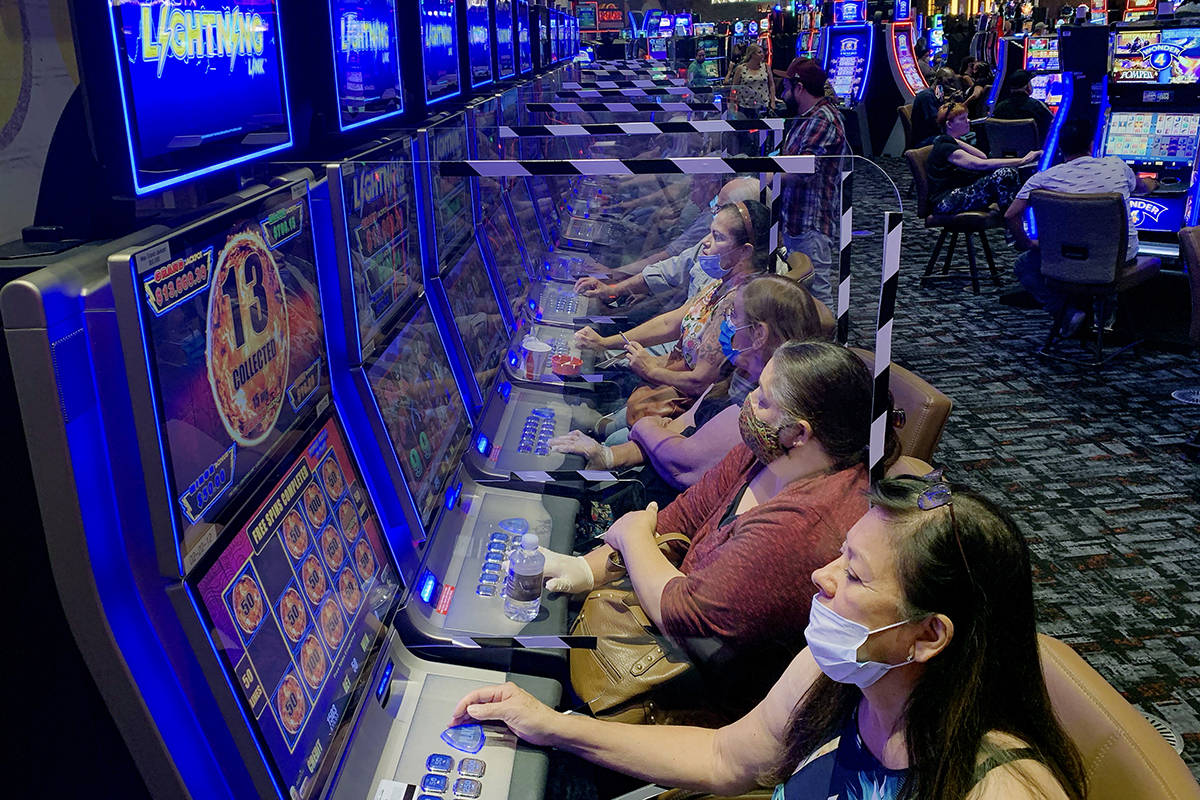 Plexiglass shields players as they gamble at Gila River Casino's Lone Butte location on the pac ...