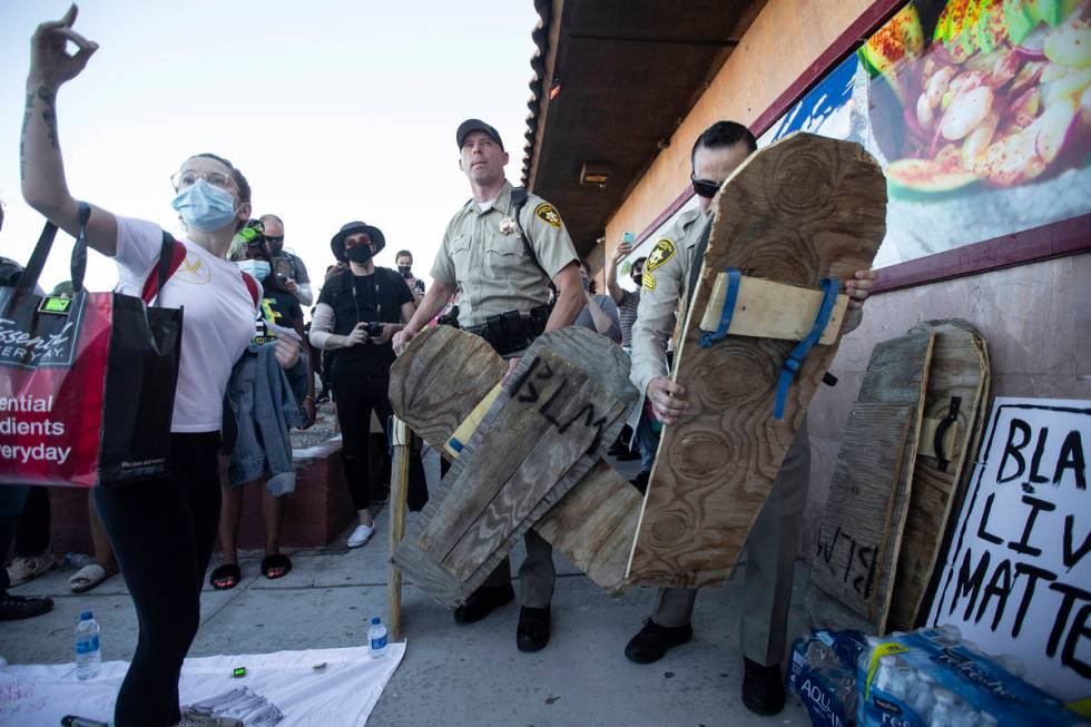 Las Vegas police seize wooden signs they deemed to be a threat during a Juneteenth rally organi ...