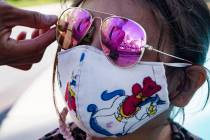 Jannete Gurrola, of Los Angeles, adjusts the sunglasses on her daughter Nadia Saucedo, 4, outsi ...