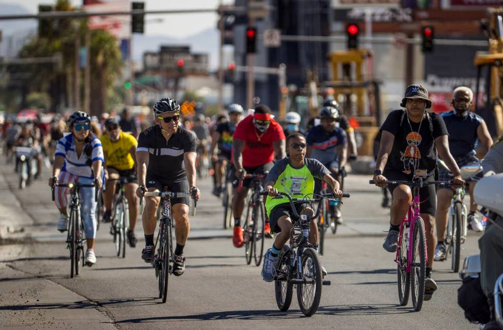 Participants in a Black Lives Matter bike ride against injustice pass by the Resort's World con ...