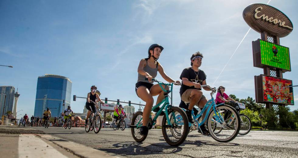 Participants in a Black Lives Matter bike ride against injustice pass by the Resort's World con ...