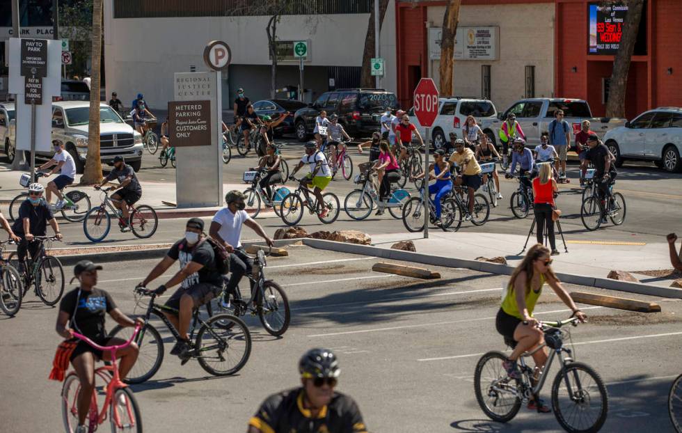 Participants in a Black Lives Matter bike ride against injustice return to a parking lot off of ...