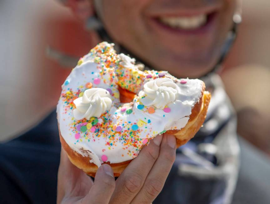 A participant in a Black Lives Matter bike ride against injustice enjoys a free snack from Donu ...