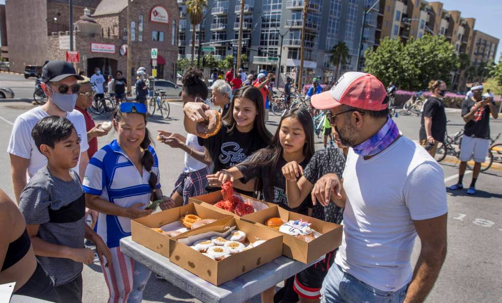 Participants in a Black Lives Matter bike ride against injustice grab a free snack from Donut B ...