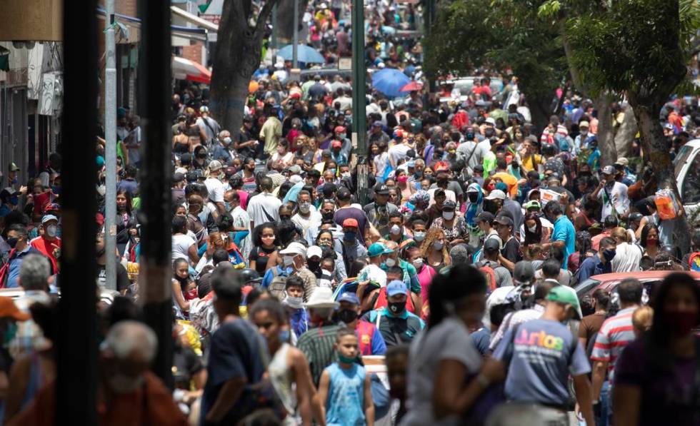 People, some wearing face masks as a measure to curb the spread of the new coronavirus, walk in ...