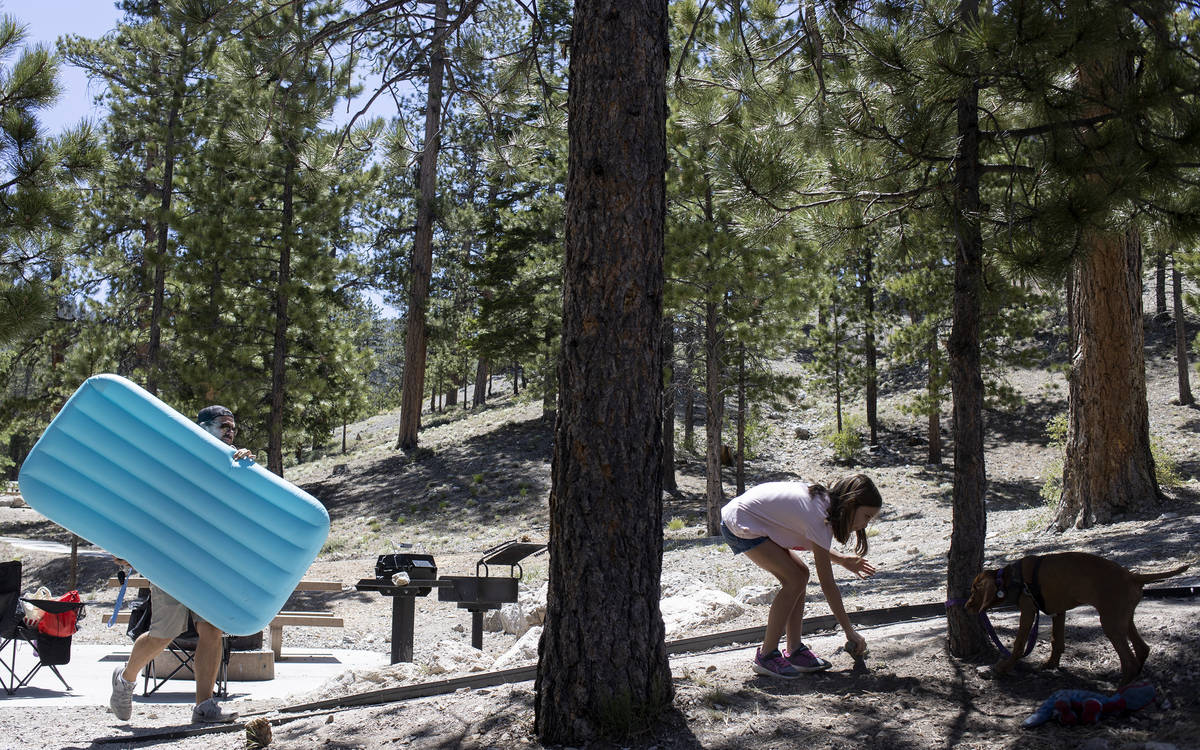 Ryan Bourque, left, carries an air mattress as his daughter, Cambrie Bourque, 9, right, plays w ...