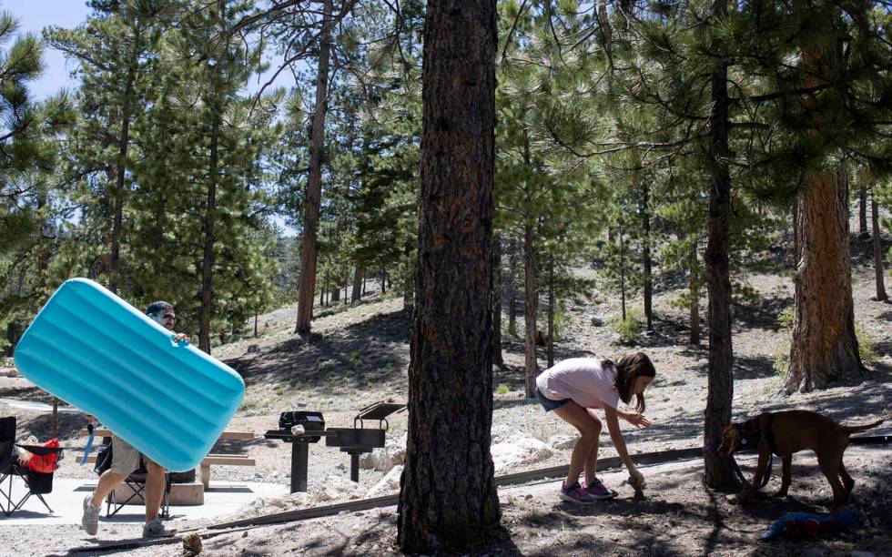 Ryan Bourque, left, carries an air mattress as his daughter, Cambrie Bourque, 9, right, plays w ...